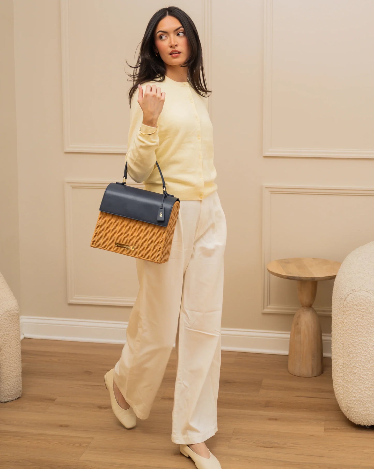 Woman carrying stylish woven and vegan leather lunch bag, paired with chic outfit for work or travel.