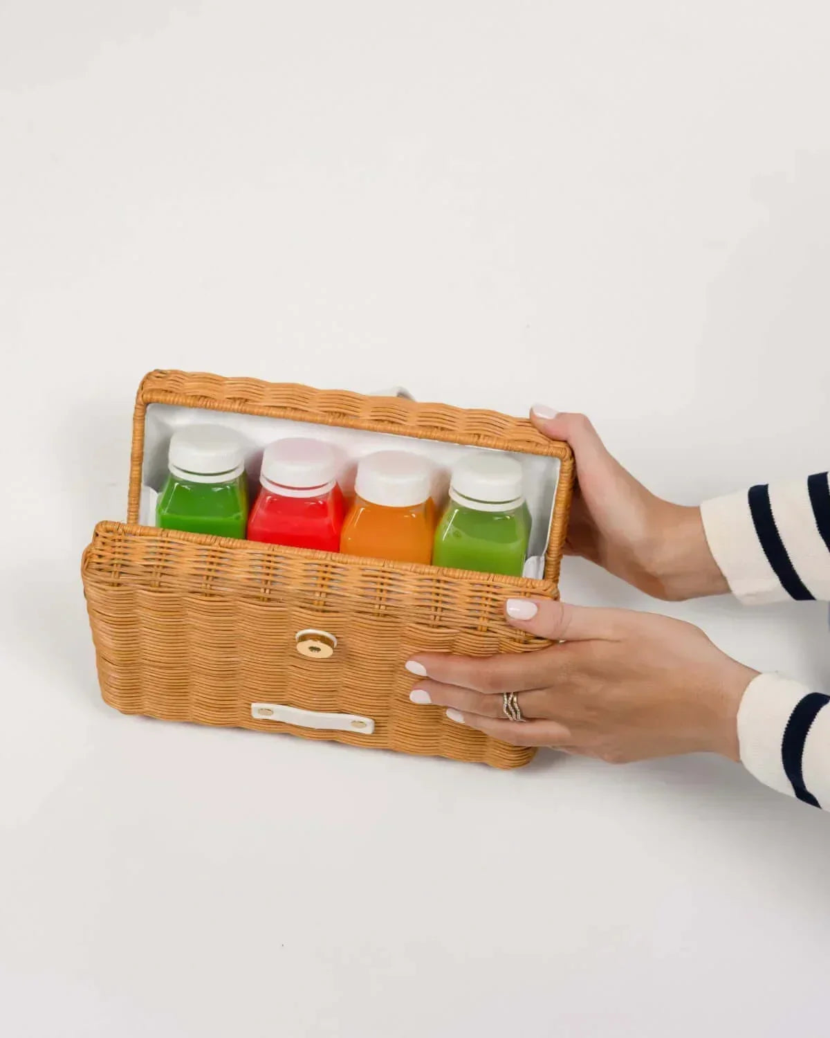 Woven insulated lunch bag holding colorful juice bottles, perfect for work or picnics