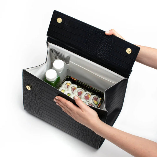 Black croc-texture insulated lunch bag holding sushi and drinks, perfect for work or travel