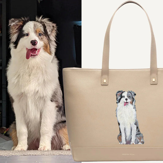Australian Shepherd dog next to beige tote bag with embroidered dog image, chic accessory