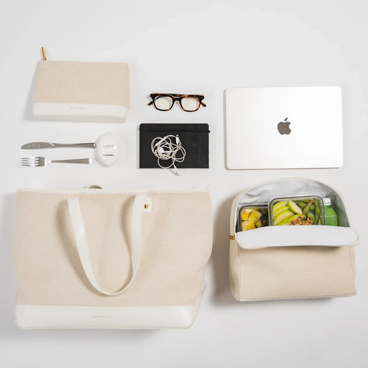 Beige canvas tote and insulated lunch bag with healthy meals, laptop, and work essentials for modern professionals