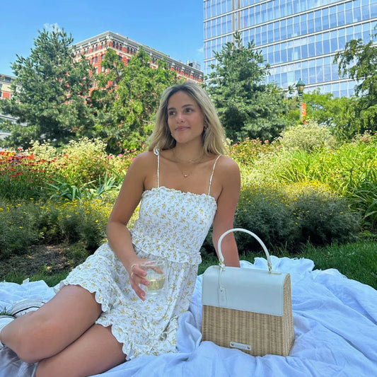 Woman enjoying picnic with chic insulated lunch tote in urban park, stylish vegan leather bag