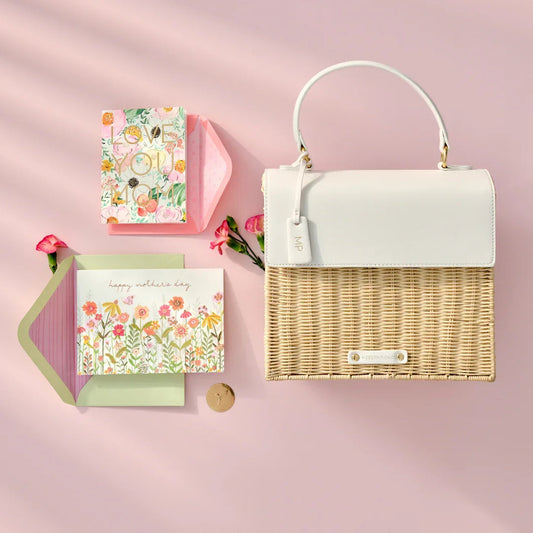 White vegan leather and woven tote with Mother's Day cards on pink background