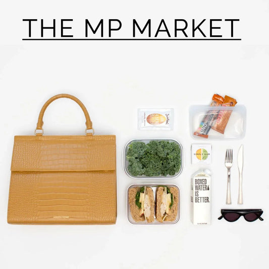 Stylish tan vegan leather lunch tote with packed sandwich, kale, snacks, and boxed water for modern workday meals.