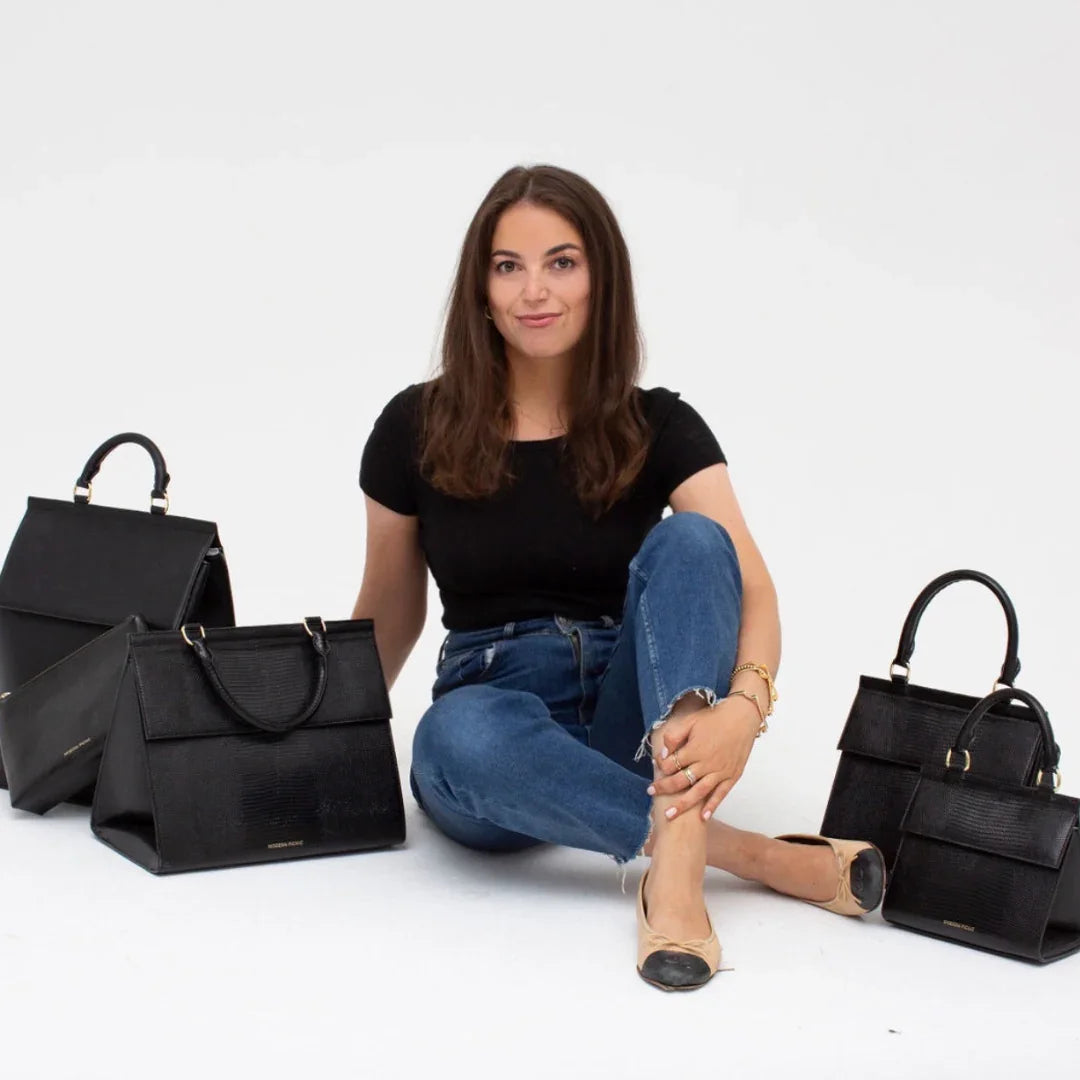 Woman sitting with black vegan leather insulated lunch bags and totes, stylish for work or travel