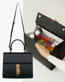 Chic black insulated lunch bag with dog print, open to show organized food containers inside.