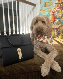 Goldendoodle dog with printed bandana beside black insulated lunch tote bag featuring dog illustration