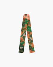 Orange and green patterned scarf with tropical leaves and elephants, stylish accessory on white background