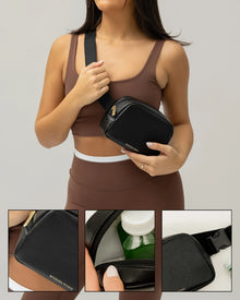 Woman wearing a black insulated vegan leather crossbody lunch bag with gold zipper and bottle inside.