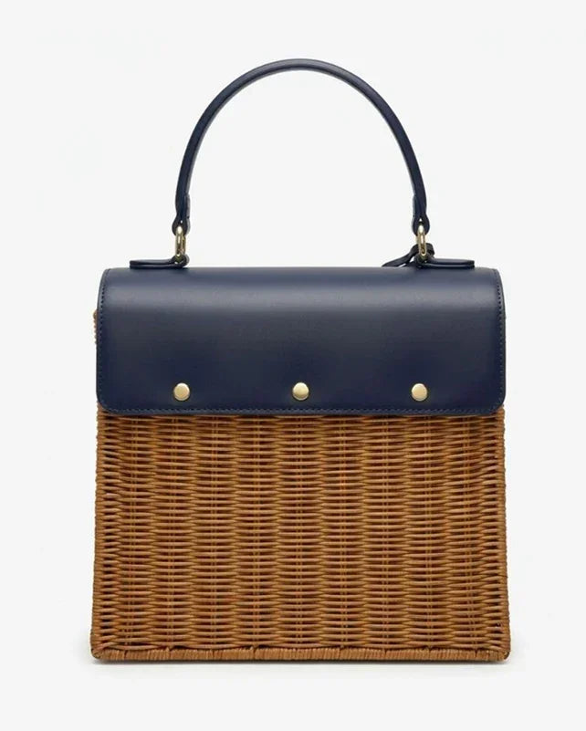 Navy vegan leather top with woven wicker body, gold hardware, and top handle—stylish insulated lunch tote