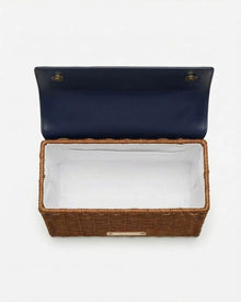 Woven basket-style lunch bag with navy lid and white interior lining, ideal for chic picnics or work meals.