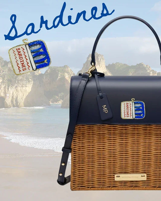 Navy and wicker tote bag with sardine can charm, beach backdrop, stylish picnic accessory