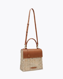 Woven straw tote with brown leather accents and adjustable strap, perfect for stylish everyday use.