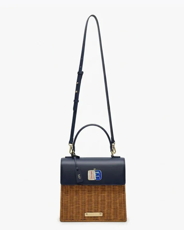 Stylish navy vegan leather and woven tote bag with adjustable strap, perfect for work or travel.