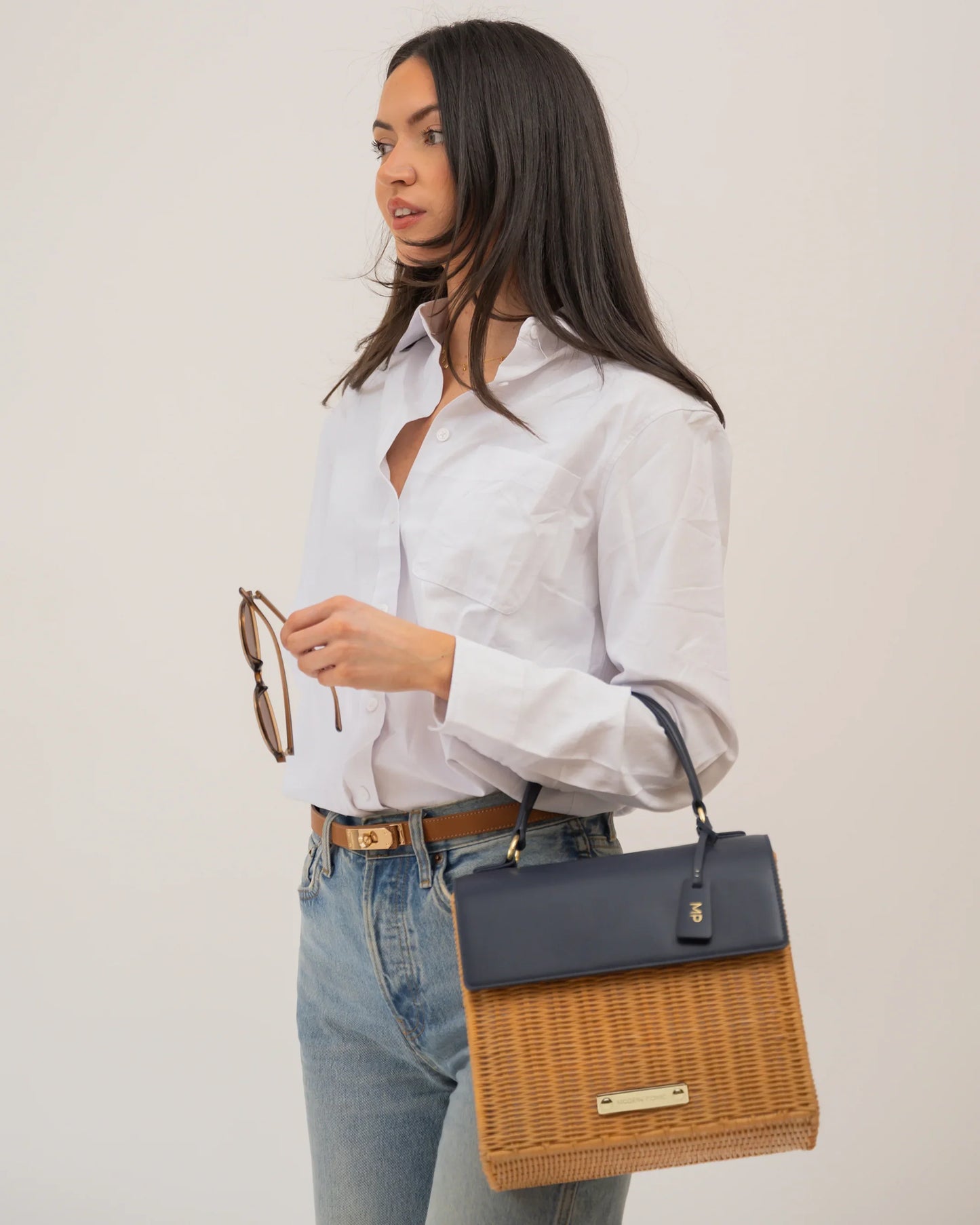 Stylish woman carrying a woven and vegan leather tote bag, perfect for work or travel.