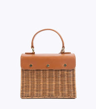 Back view of The Wicker Mini in Brown Wicker Lobster by Modern Picnic, showing the hand-woven wicker exterior, brown vegan leather flap with gold snap details, and top handle.