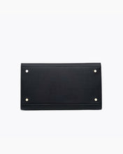 A close-up, straight-on product shot of the bottom of a black handbag. The image clearly shows the base, which is reinforced with four small gold-tone metal feet/studs for protection.