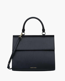 A structured black purse. It features a curved top handle, a fold-over flap closure, a thin, adjustable shoulder strap attached to one side with gold-tone hardware, and the MODERN PICNIC logo subtly stamped in gold near the bottom edge.