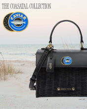 Black Wicker Mini – Caviar by Modern Picnic displayed on a coastal beach backdrop, featuring a hand-woven black wicker exterior, black vegan leather top, gold hardware, and a caviar graphic.
