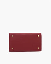 The bottom of the structured red smooth luncher is shown, featuring a flat, rectangular base protected by four small, circular gold-toned metal feet, all set against a clean white background.