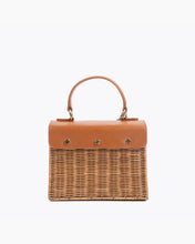 Back view of the Brown Wicker Mini Lunchbag by Modern Picnic, featuring a hand-woven wicker exterior, brown vegan leather flap with gold snap details, and top handle.