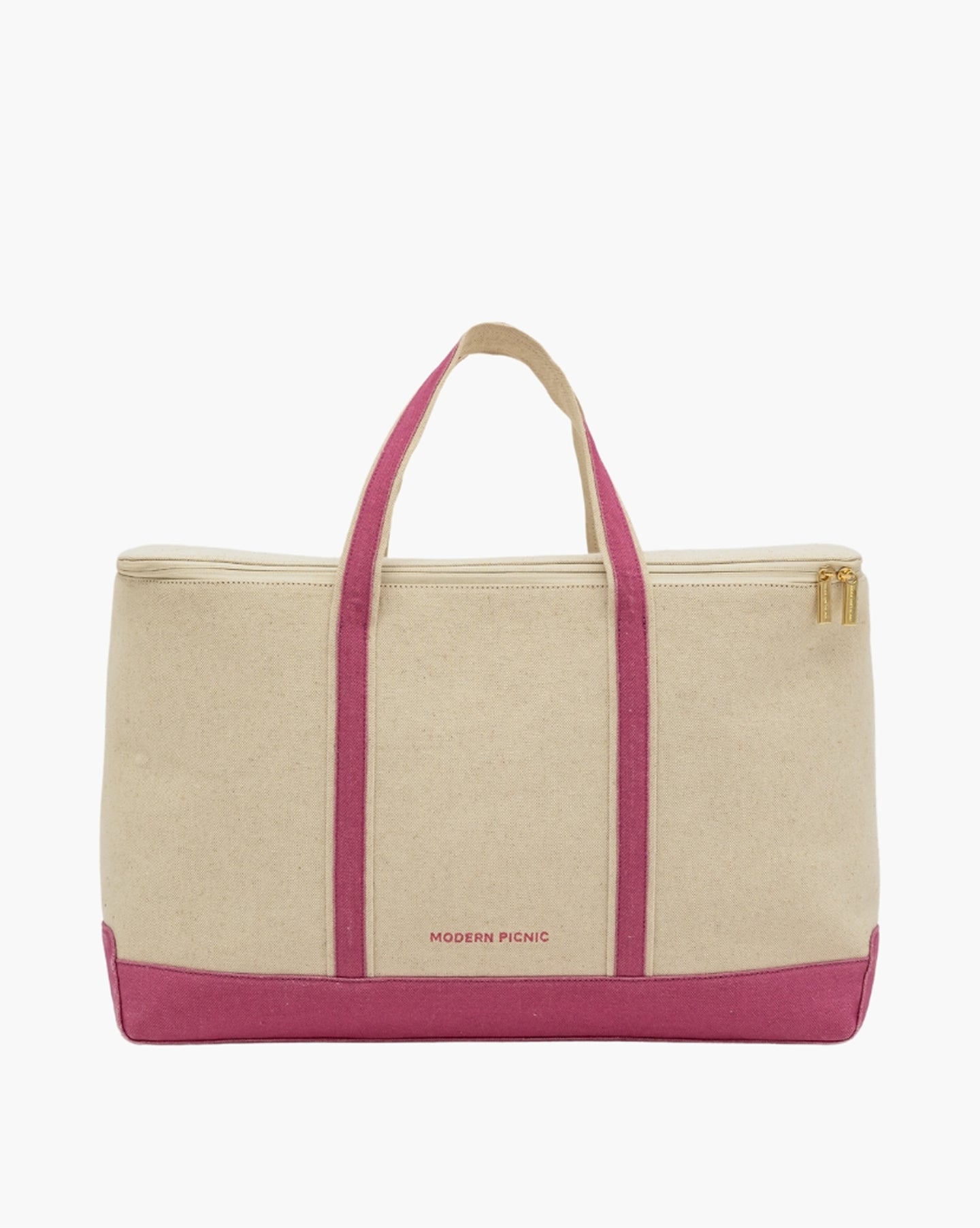A front-facing studio shot of a wide beige canvas cooler tote bag. It has a bold pink base and two vertical pink stripes running up the center, which form the pink and beige top handles. The bag features a gold zipper closure and the logo 