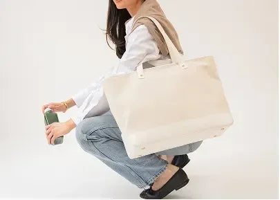 Woman holding stylish insulated tote bag and green bottle, perfect for modern picnics and daily commutes.