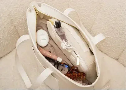 Stylish cream tote bag with organized contents, perfect for work or travel