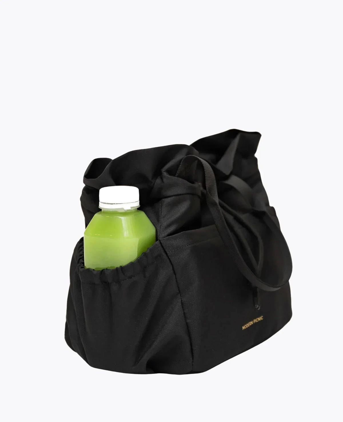Black insulated lunch bag with a side pocket containing a green juice bottle.