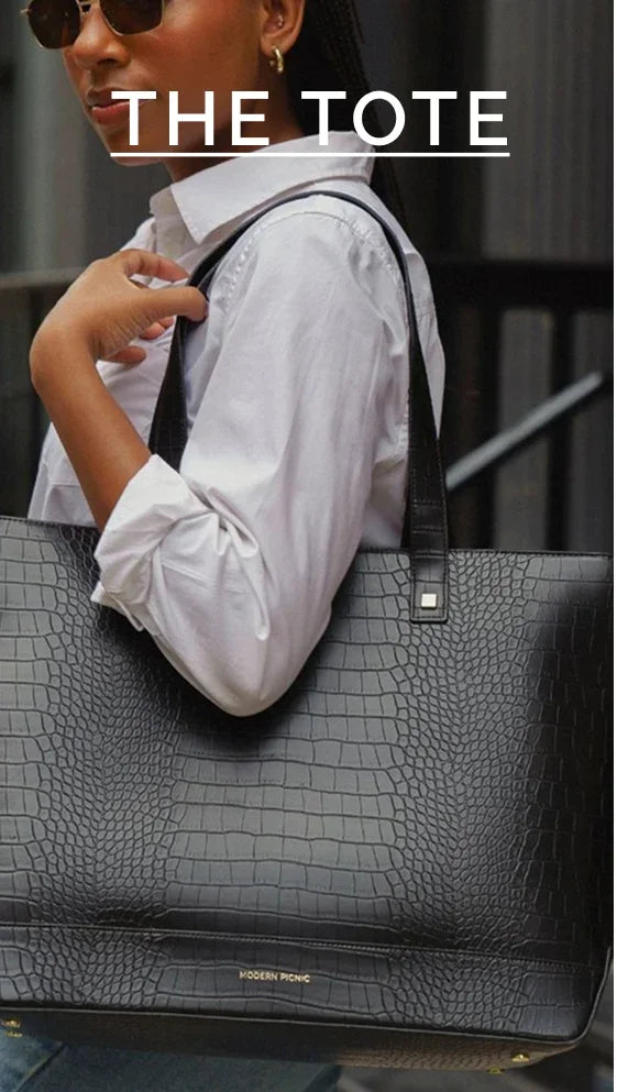 A woman carrying a black crocodile-embossed vegan leather tote bag for work.