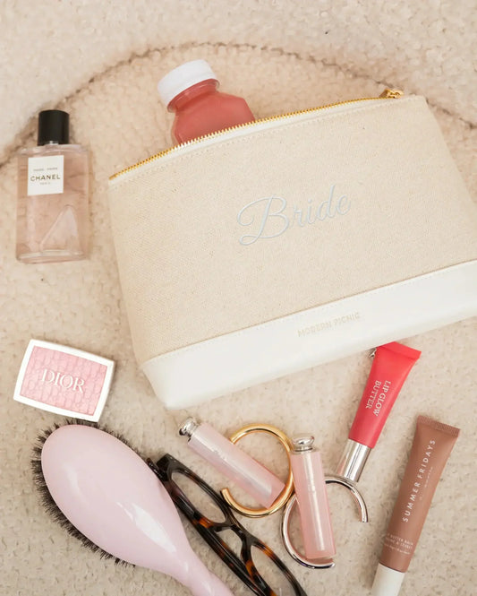 Bride embroidered canvas pouch with beauty essentials and a pink drink, styled for chic everyday use.