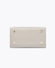 Bottom view of the Kids Mini Stone bag by Modern Picnic, showing the stone-colored vegan leather base with four gold metal feet, clean stitching, and a structured rectangular design displayed on a white background.