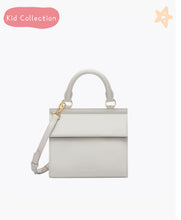 Kids Mini Stone bag by Modern Picnic displayed against a clean white background, featuring a mini structured silhouette in stone-colored vegan leather with a top handle, detachable crossbody strap, and gold hardware; part of the Kid Collection with playful star and label accents at the top of the image.