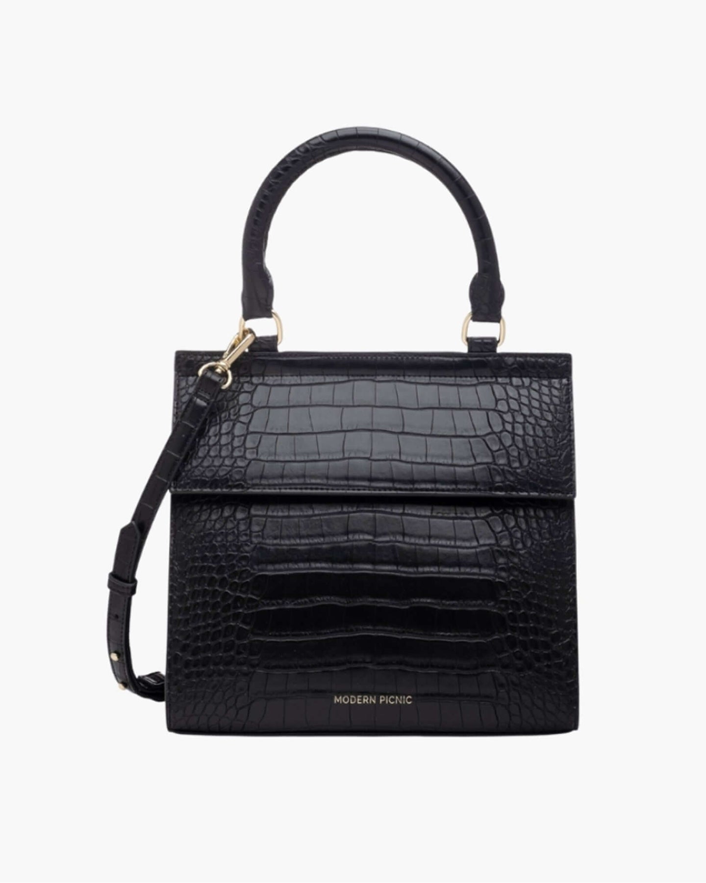 A front-facing studio shot of a structured black top-handle handbag. The bag is fully covered in a crocodile-embossed texture and features a clean flap closure, a detachable matching shoulder strap, and gold hardware. The logo 