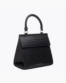 A three-quarter studio shot of a structured black top-handle handbag. The bag features an all-over crocodile-embossed texture, a prominent flap closure, and a visible gold "MODERN PICNIC" logo near the bottom front.