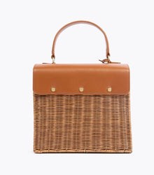 A back view of the structured picnic-style handbag. The bottom two-thirds of the bag are made of brown woven wicker, and the top flap is smooth brown vegan leather. The back of the leather flap is secured to the wicker body with three visible gold-tone fasteners.