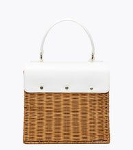 A back view of the structured, smaller picnic-style handbag. The bottom two-thirds of the bag are made of natural brown woven wicker, and the top flap is smooth white vegan leather. The back of the white leather flap is secured to the wicker body with three visible gold-tone snap closures.