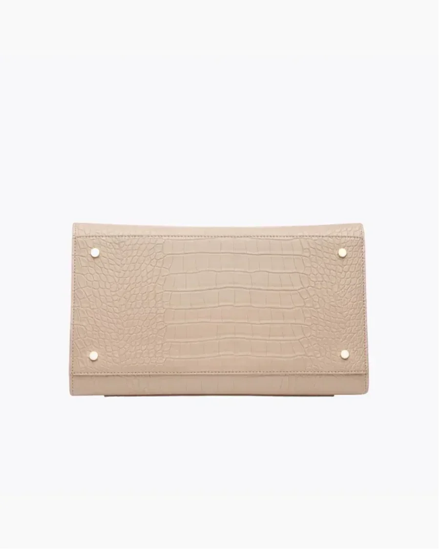 Beige vegan leather bag with crocodile texture and gold-tone stud accents, bottom view