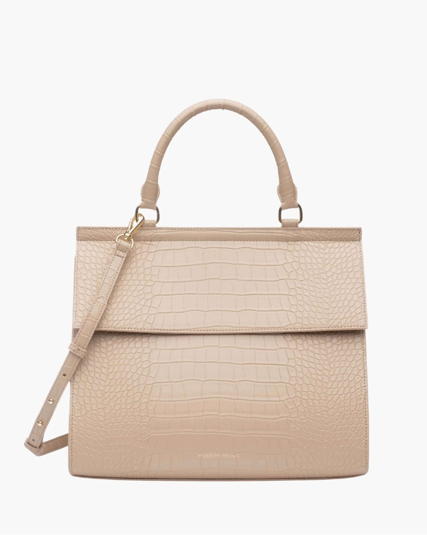 A front-facing studio shot of a structured top-handle handbag in a light cream color. The main body and flap closure feature a crocodile-embossed texture. The bag has a matching top handle, a detachable shoulder strap, and gold hardware. The logo, 