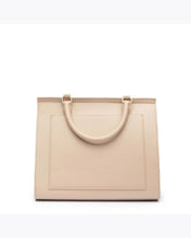 A close-up studio shot showing the back view of a cream top-handle handbag. The back features a flat, rectangular slip pocket outline and a single curved top handle attached with gold hardware.
