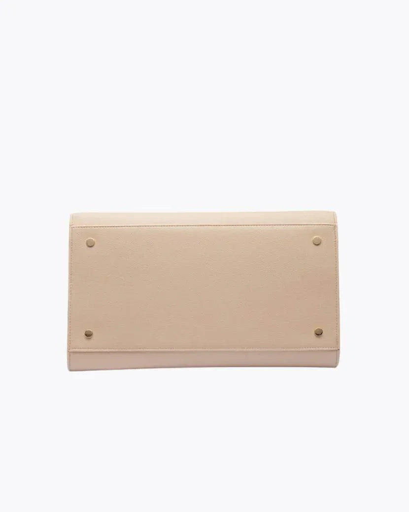 A view of the bottom of the cream-colored handbag, showing the flat base with four small gold metal feet (studs) designed to protect the material.