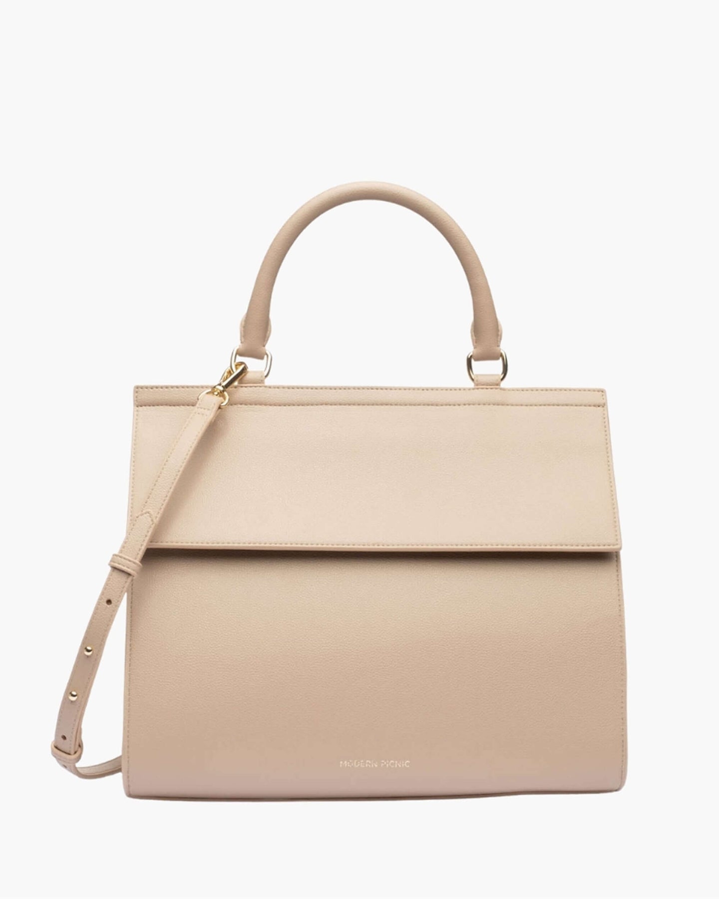 A front-facing studio shot of a structured top-handle handbag in a cream color with a flap closure. The bag features a detachable matching shoulder strap and small gold hardware. The logo, 