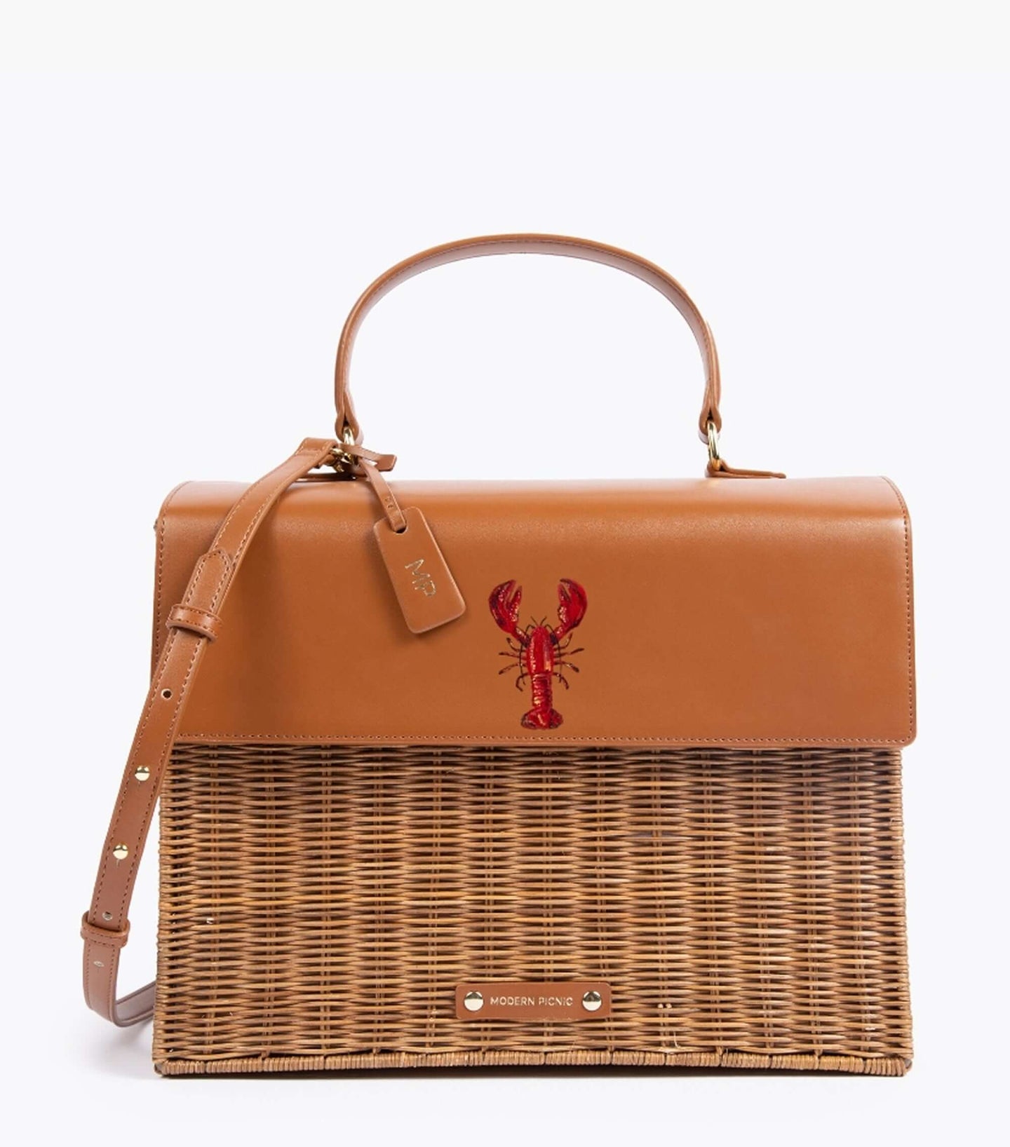 A front-facing studio shot of a structured top-handle handbag with a novelty design. The bag features a smooth brown vegan leather top flap, handle, and adjustable shoulder strap, detailed with a hand-painted red lobster design. The bottom section of the bag is made of brown woven wicker. A brown leather hang tag with gold 