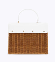 A back view of the structured picnic-style handbag. The bottom two-thirds of the bag are made of brown woven wicker, and the top flap is smooth white vegan leather. The back of the white leather flap is visibly secured to the wicker body with four gold-tone fasteners.