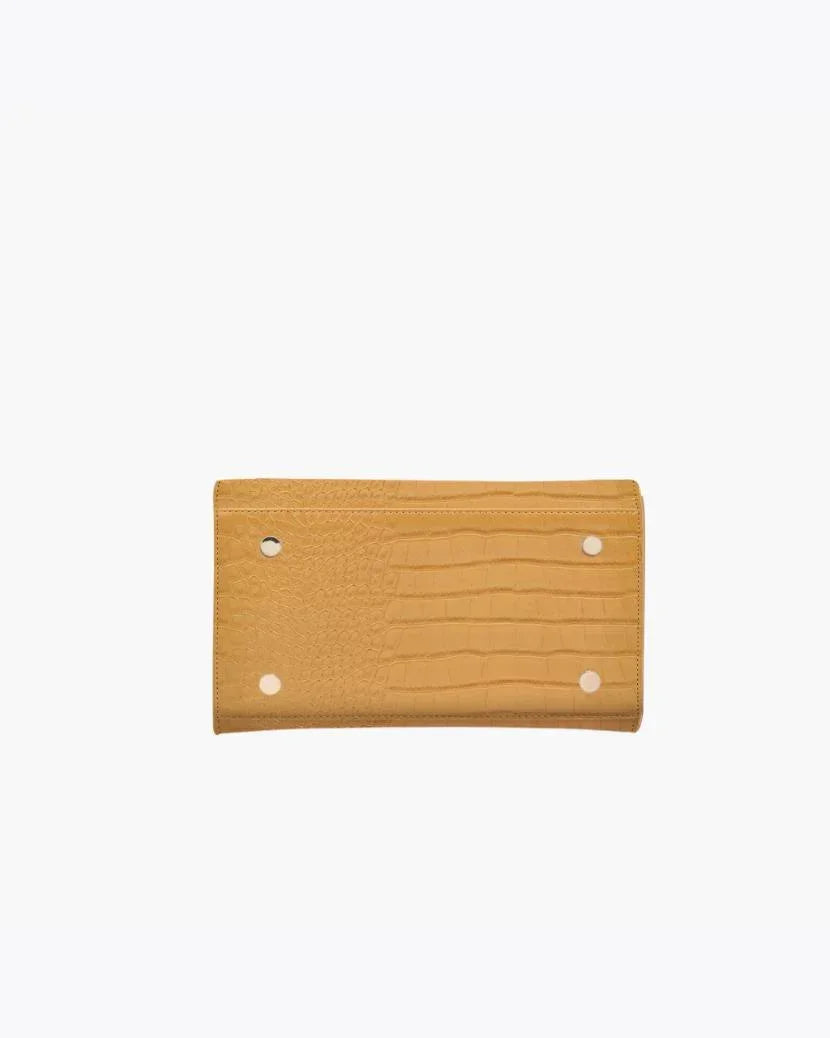 Bottom view of the Marigold Croc Kids Mini by Modern Picnic, showcasing the marigold yellow croc-embossed vegan leather exterior with four gold metal feet for protection and durability, displayed on a white background.