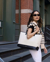 Modern Picnic canvas tote with black trim resting on a white counter beside a sink.