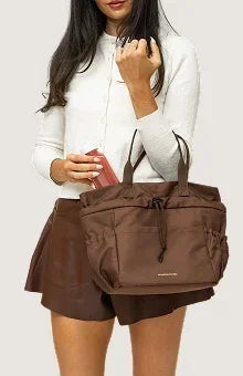 Woman carrying a chic brown insulated vegan leather tote bag for work or travel.
