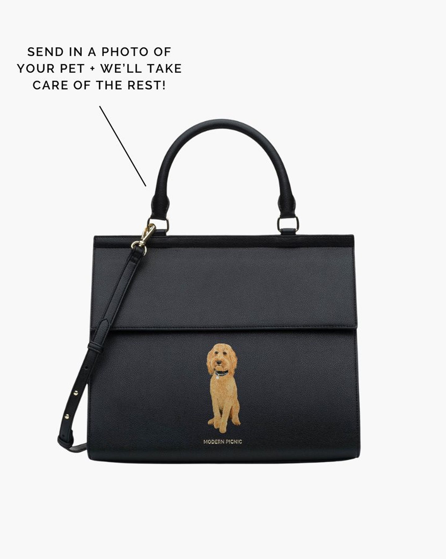 A studio shot of a structured, large black handbag made of pebbled vegan leather, featuring a hand-painted portrait of a tan Goldendoodle dog sitting on the front flap. Text on the image advertises the custom service: 