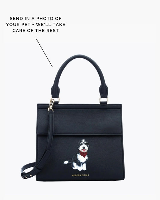 Black insulated lunch bag with custom pet illustration, top handle and crossbody strap.