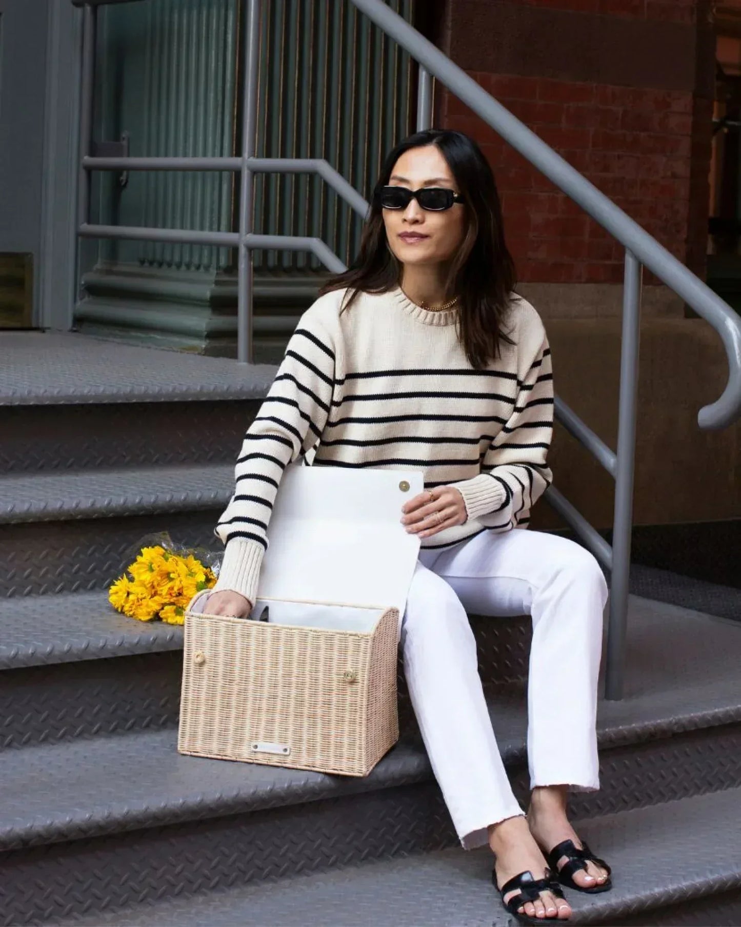 Woman with wicker insulated lunch tote on city steps, chic picnic bag for work or travel
